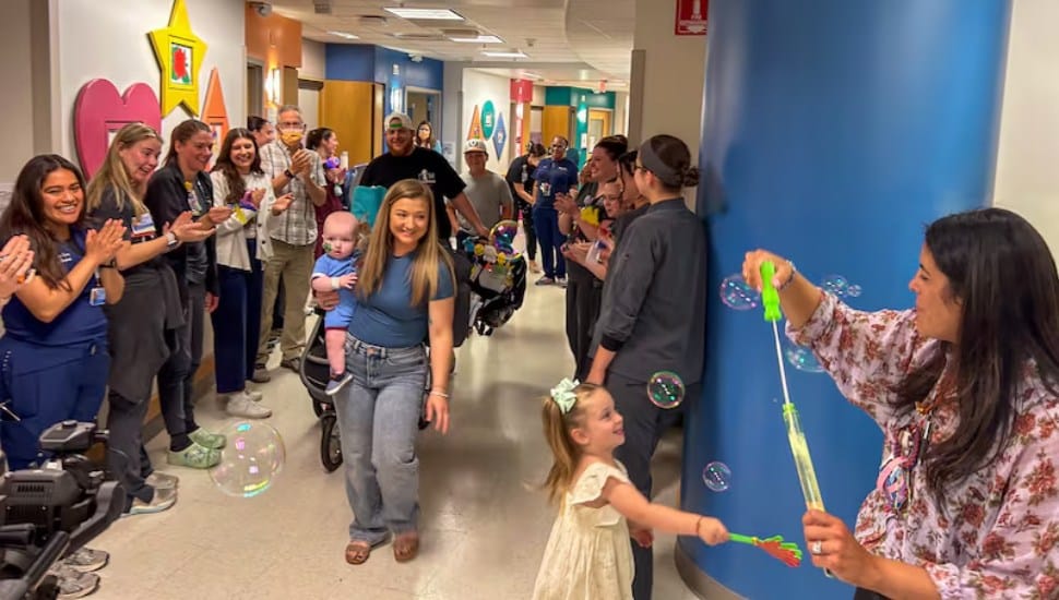 Baby KJ with mom Nicole and father Kyle in the hallway of CHOP as they receive applause from the staff on their way home.