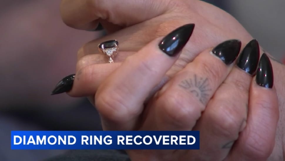 A close-up of a woman's hands with an engagement ring on finger.