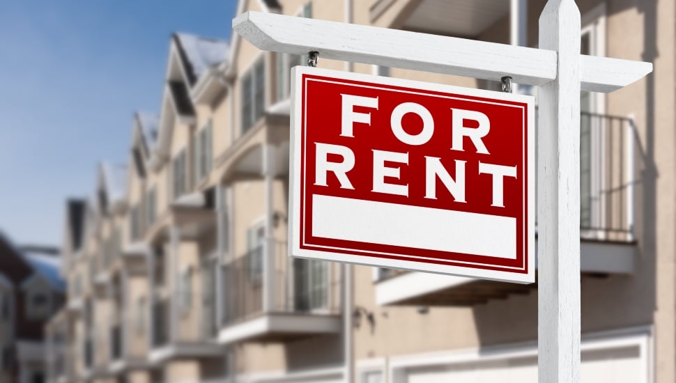 For Rent sign in front of a row of apartment condos.