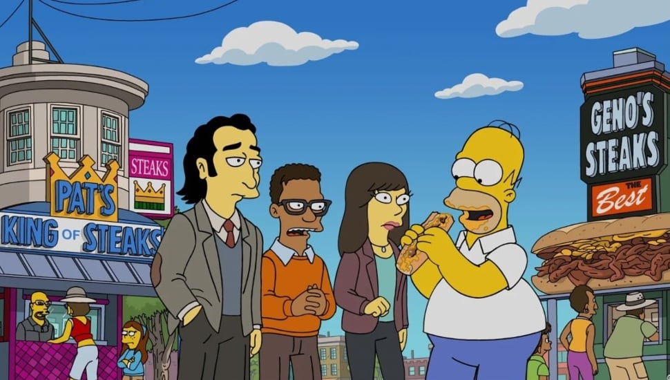 Homer Simpson eating a cheesesteak between Pat's and Geno's.