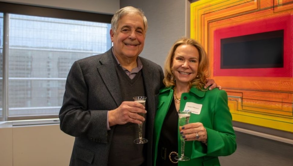 Larry Ceisler and Maggy Wilkinson celebrating with a glass of champagne.