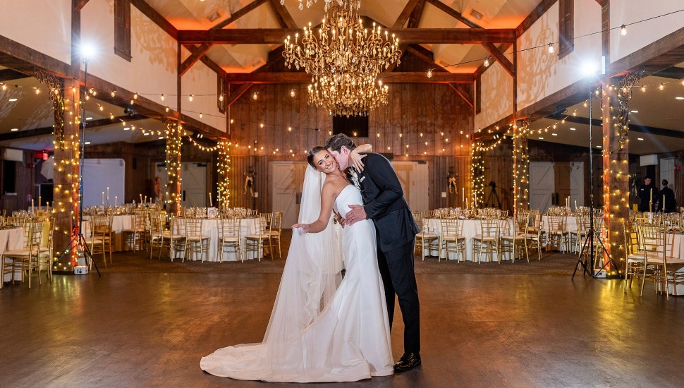 A newlywed company embrace on the dance floor at Normandy Farm.