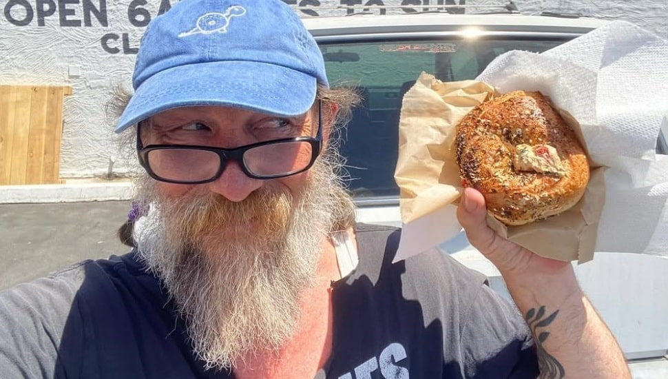 Philip Korshak holding up a bagel.