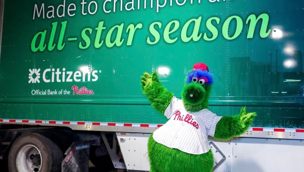 Phillie Phanatic posing in front of Phillies truck.