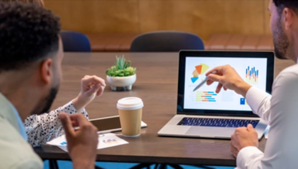 Couple looks at their portfolio on a computer with their wealth manager.