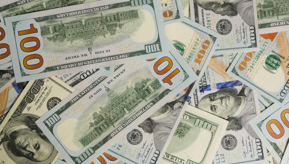 A large number of American 100 dollar bills lie on the floor.