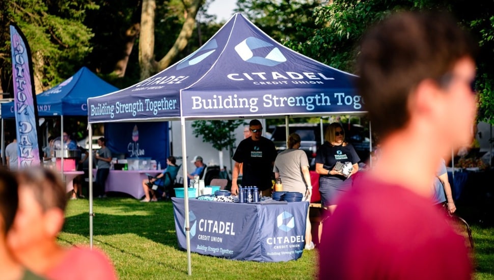 Credit union's promotional tent at outdoor event.