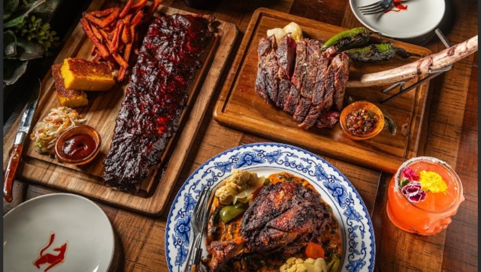 Carne asada, sweet potato fries, ribs, and cocktails on a table.