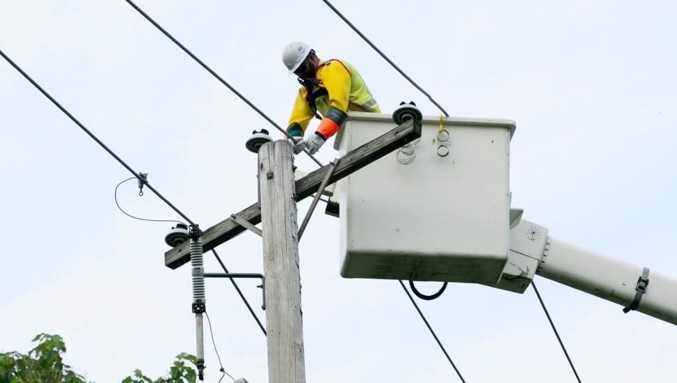 Utility worker fixes power line.