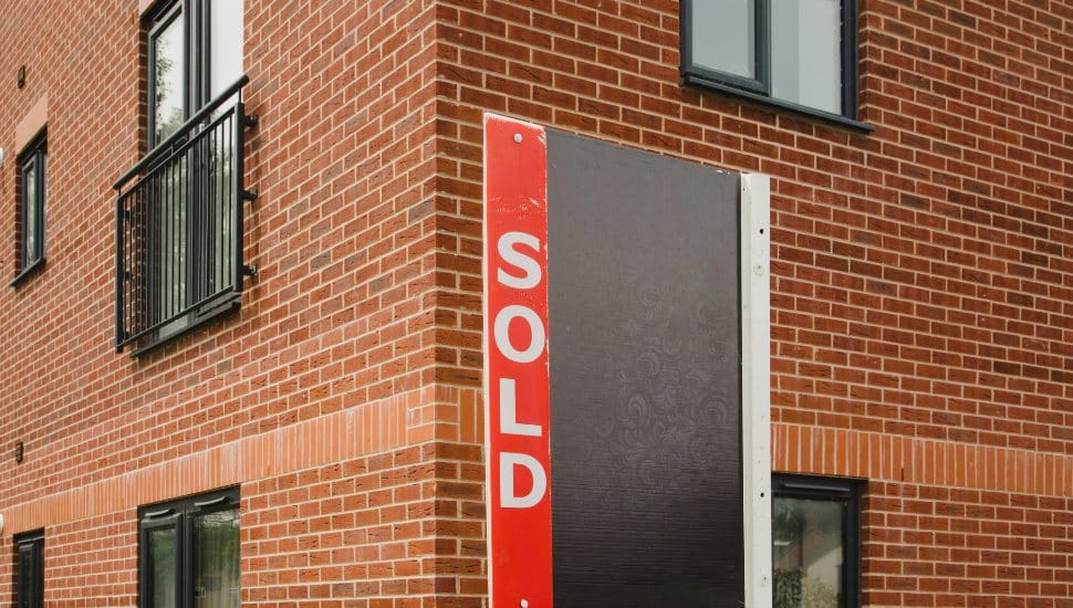 Sold sign on side of brick building.