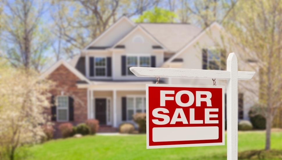 A home with a for sale sign out front