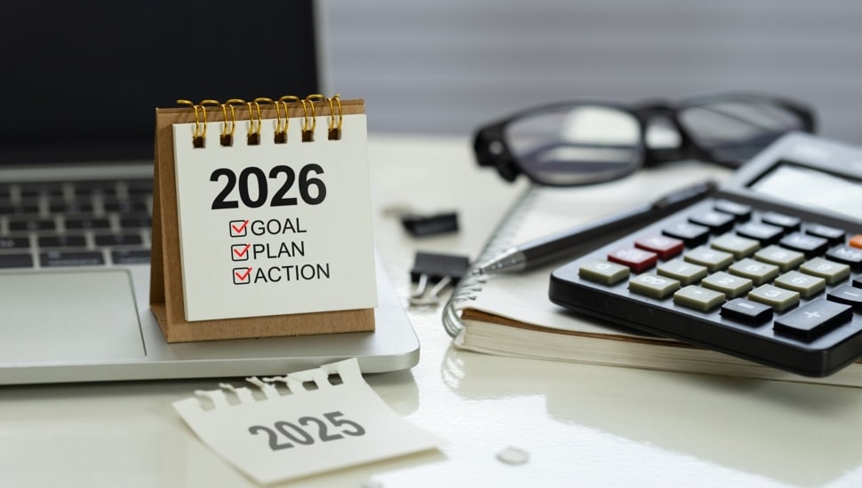 Desk calendar 2026 with checklist Goal, Plan, Action on office workspace beside calculator.