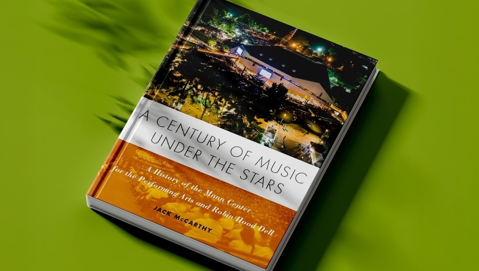 A copy of the book, "A Century of Music Under the Stars: A History of the Mann Center for the Performing Arts and Robin Hood Dell," with a green background.