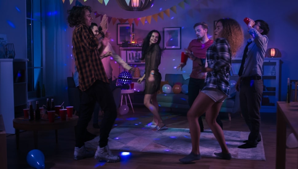 Diverse group of friends having fun, dancing, socializing at a party.