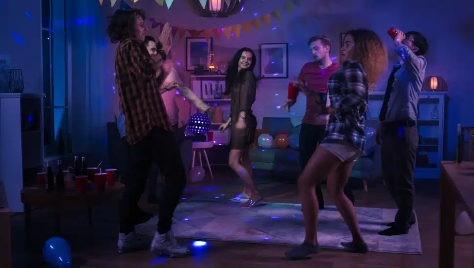 Diverse group of friends having fun, dancing, socializing at a party.