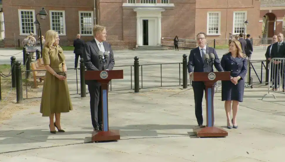 King Willem-Alexander and Josh Shapiro standing at separate podiums, along with their wives, Queen Máxima and Lori Shapiro.