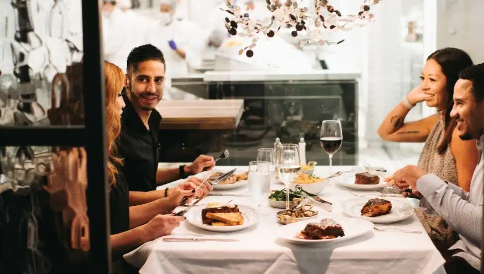 Four people enjoying meal at Steak 48.