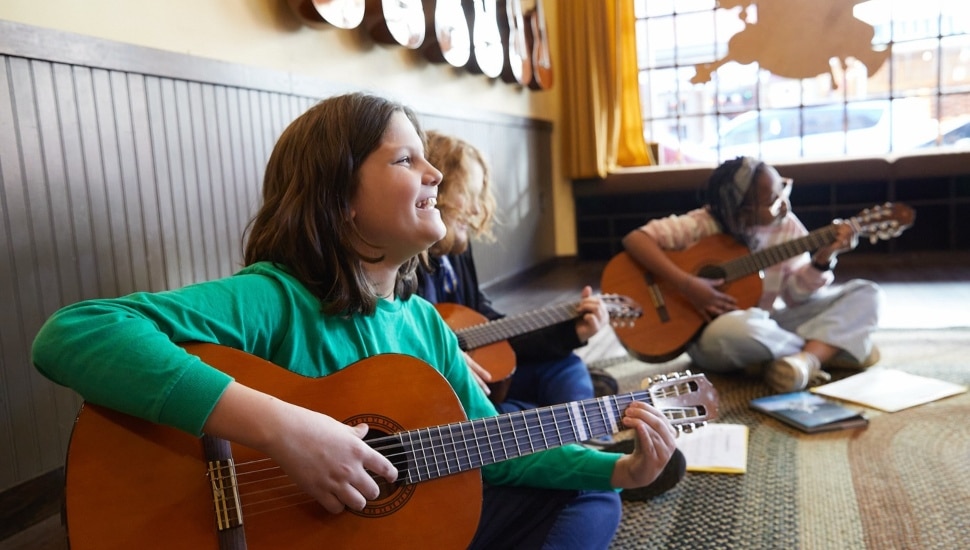 Three young girls playing the guitar.