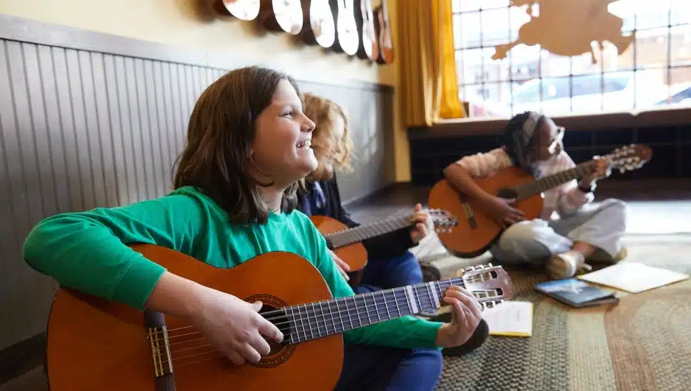 Three young girls playing the guitar.