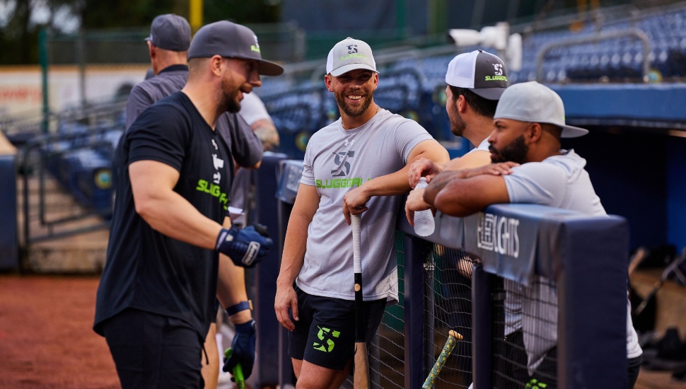 Baseball players congregate in a dugout.