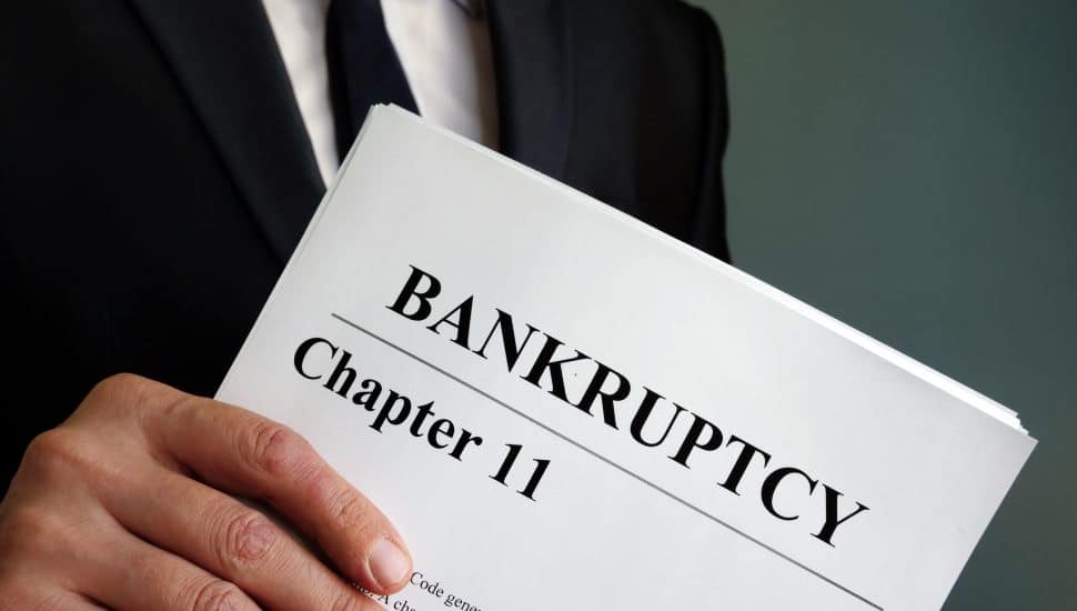Man holds Bankruptcy Chapter 11 agreement documents.