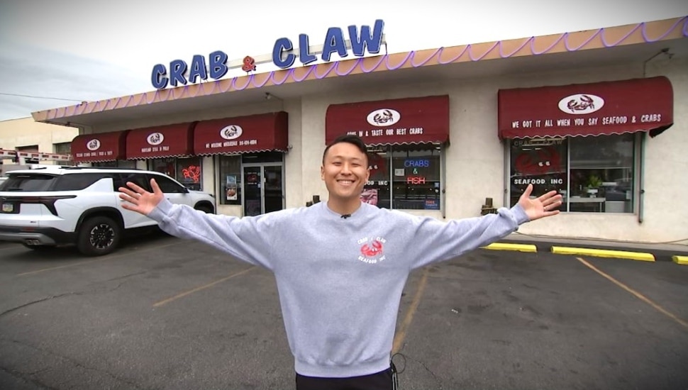 Andrew Min standing in front of Crab & Claw Seafood storefront on Ogontz Avenue in Philadelphia.