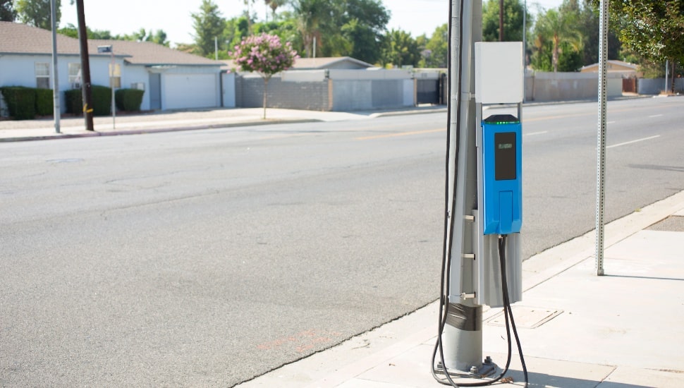 A view of an electric vehicle charging station, installed on the side of a street.