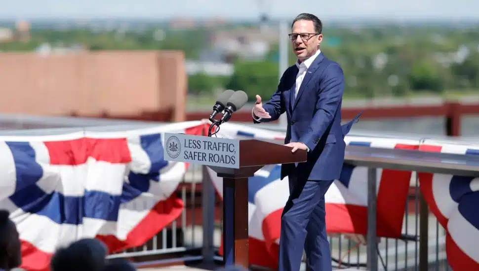 Gov. Josh Shapiro speaking at a podium at Citizens Bank Park announcing a $30 million traffic overhaul for Philadelphia's Stadium District.