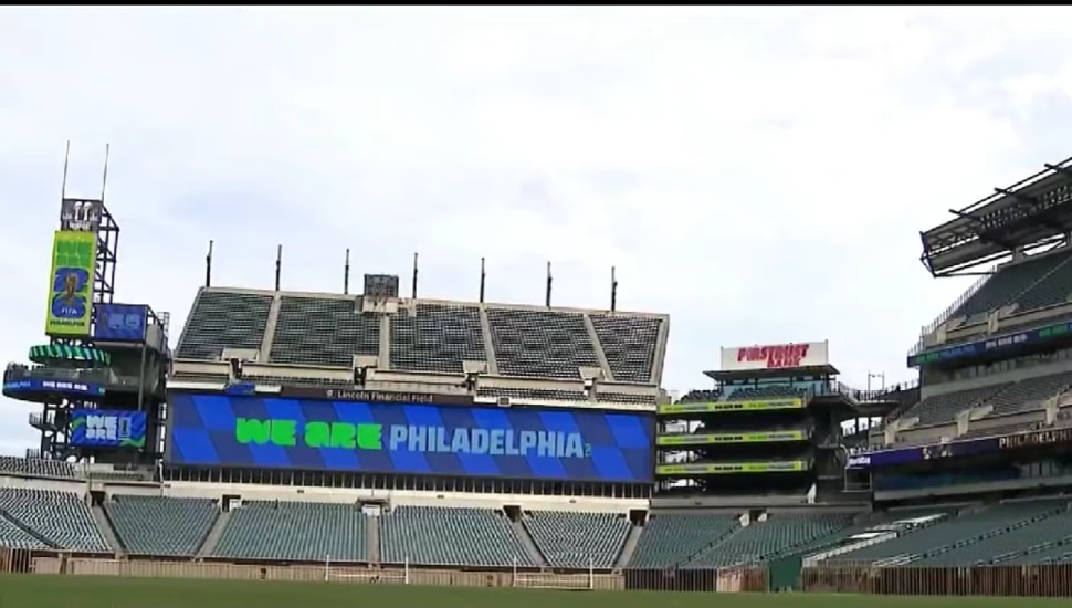 Lincoln Financial Field interior showing FIFA World Cup 2026 "We Are Philadelphia" branding on the stadium scoreboard with freshly laid pitch visible.
