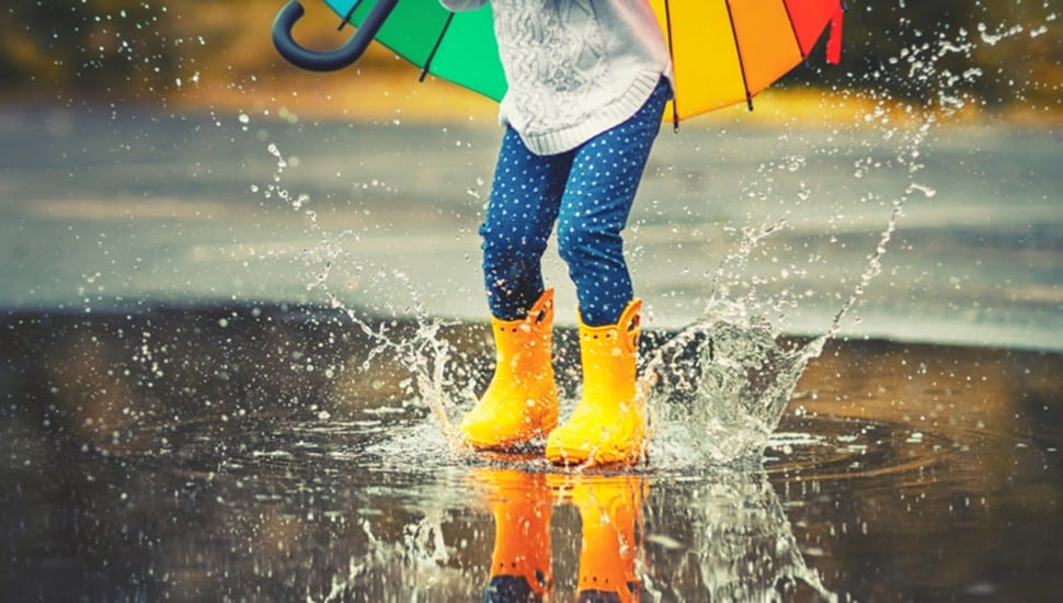 A child plays in a puddle.