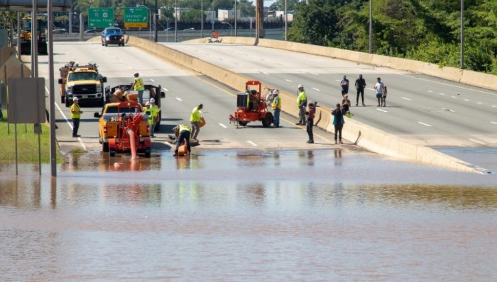 Highway crews and pedestrians survey a flooded expressway in Philadelphia after Hurricane Ida caused the Schuylkill River to overflow in 2021.